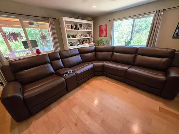 A large leather power-reclining sectional delivered and set up in a Nevada County home with hardwood floors