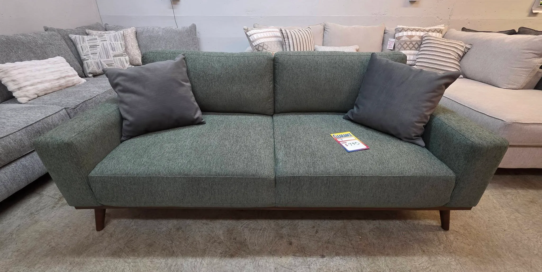 A camel leather sectional with chaise and decorative pillows on the BoxDrop floor